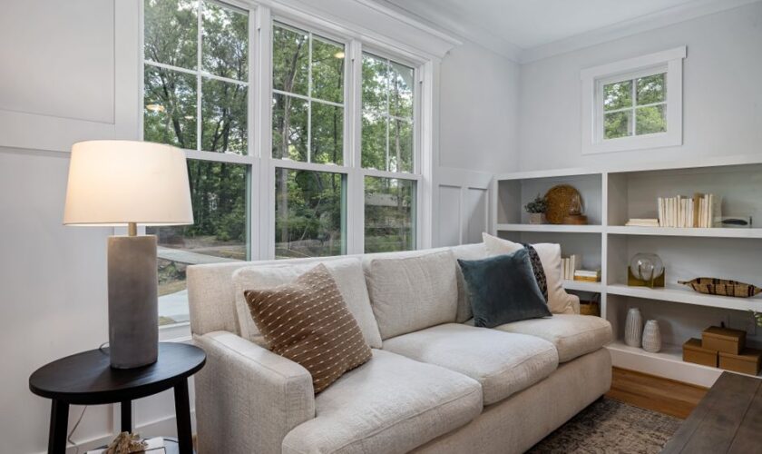 Inviting living room featuring a cozy sofa, large windows, and stylish decor.