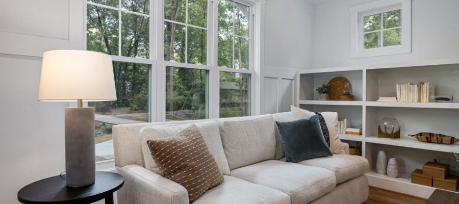 Inviting living room featuring a cozy sofa, large windows, and stylish decor.