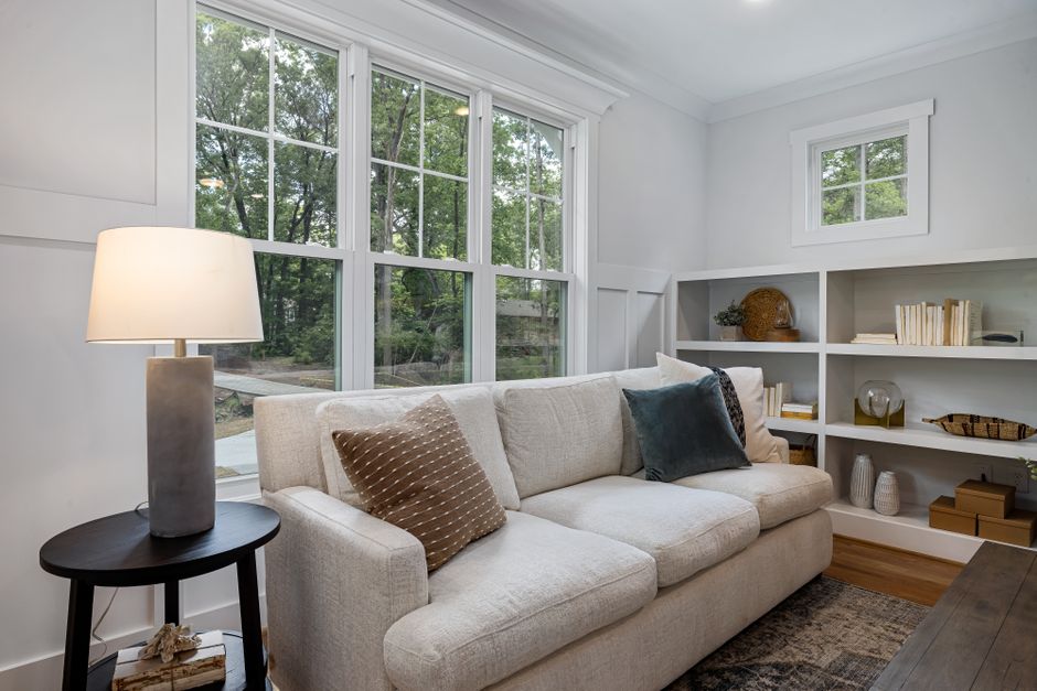 Inviting living room featuring a cozy sofa, large windows, and stylish decor.