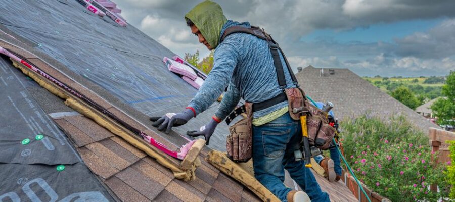 Roofers working on shingle installation on a home in Fort Worth, Texas under blue skies.