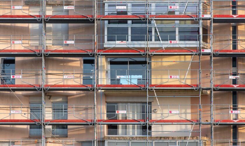 Scaffolding covers an urban building facade, capturing a construction site in detail.