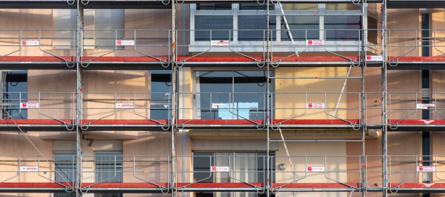 Scaffolding covers an urban building facade, capturing a construction site in detail.