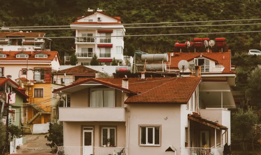 Scenic hillside neighborhood showcasing charming multi-storey homes with vibrant red roofs.