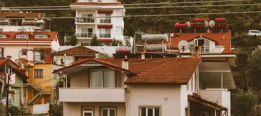 Scenic hillside neighborhood showcasing charming multi-storey homes with vibrant red roofs.