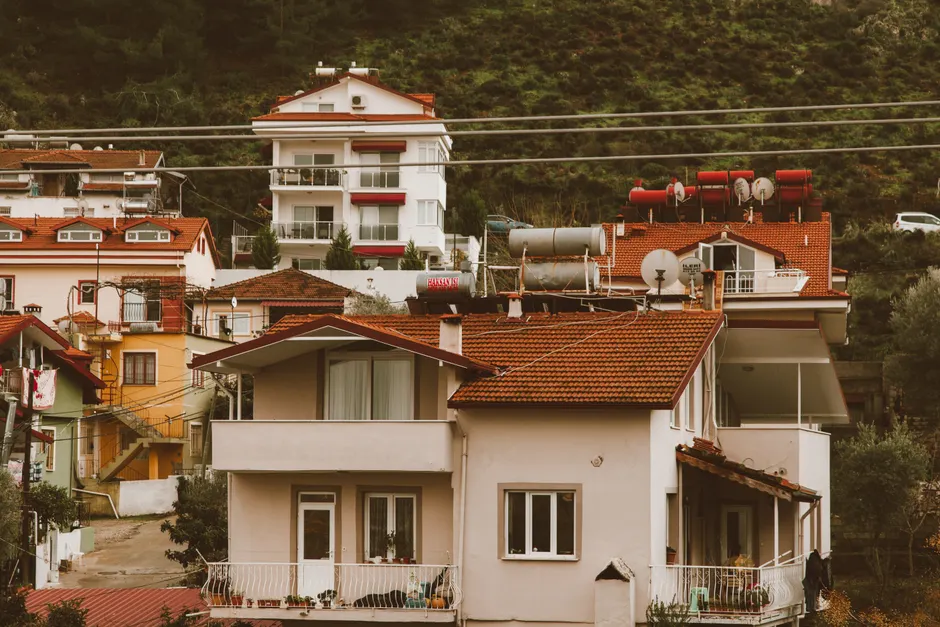 Scenic hillside neighborhood showcasing charming multi-storey homes with vibrant red roofs.