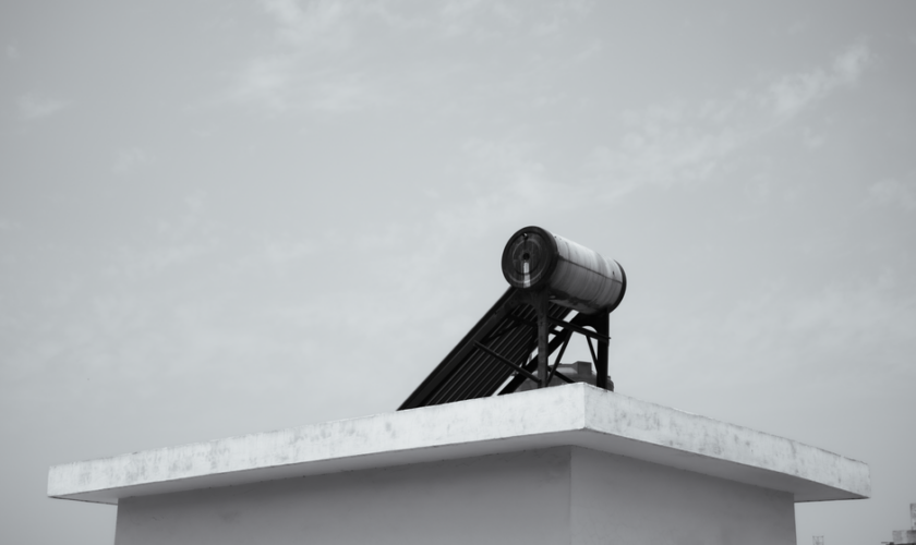 Solar water heater on a rooftop against a clear sky, energy efficient design.