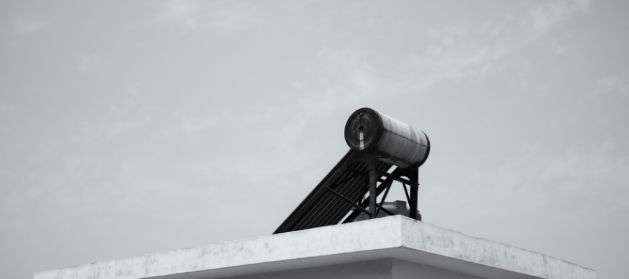 Solar water heater on a rooftop against a clear sky, energy efficient design.