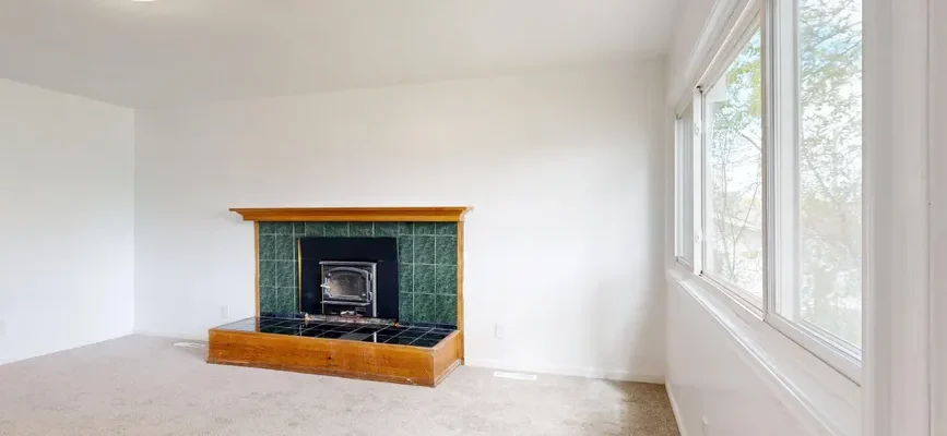 Spacious living room featuring a modern fireplace and large windows.