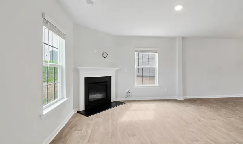 Spacious modern living room featuring a fireplace and natural light through large windows.