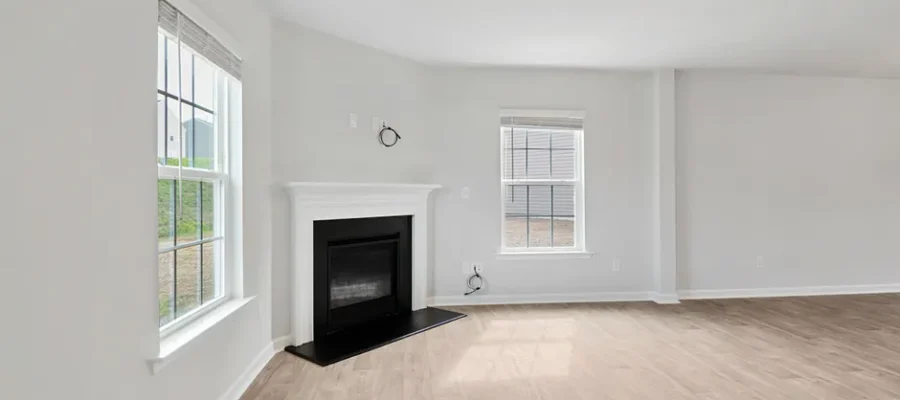 Spacious modern living room featuring a fireplace and natural light through large windows.