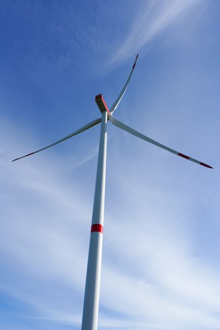 Striking view of a wind turbine set against a clear blue sky, showcasing renewable energy technology.