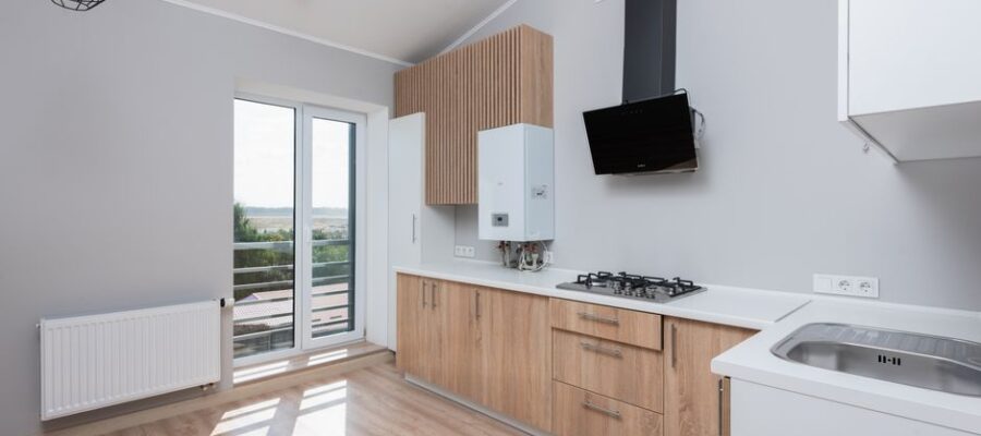 Stylish empty kitchen with wooden cabinets and large windows.