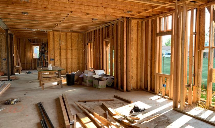 Sunlit interior with wood framing, showcasing home construction progress.