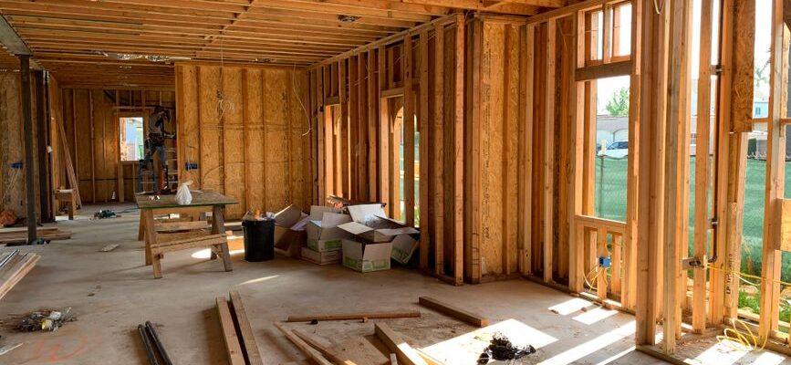 Sunlit interior with wood framing, showcasing home construction progress.
