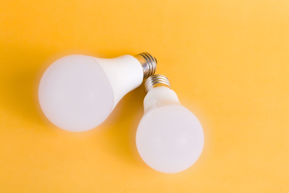 Two LED light bulbs on a bright yellow background, emphasizing modern energy-efficient lighting.