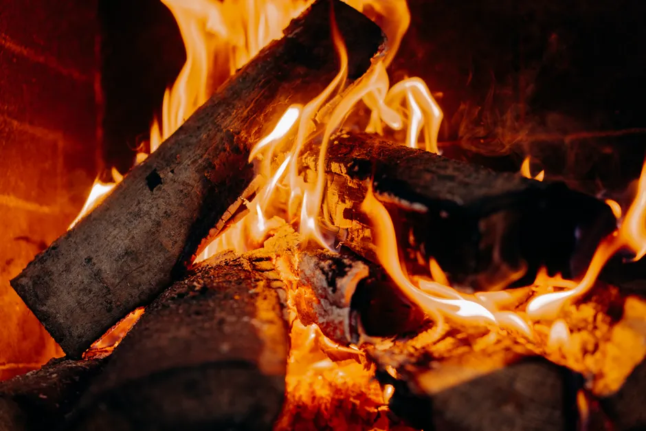 Warm and inviting close-up of burning logs in a fireplace, perfect for cozy interiors.