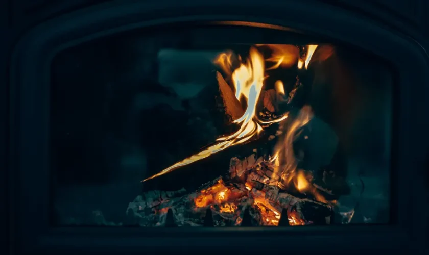 Warm close-up of a fireplace with fire burning logs, creating a cozy atmosphere.