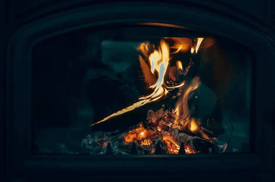 Warm close-up of a fireplace with fire burning logs, creating a cozy atmosphere.