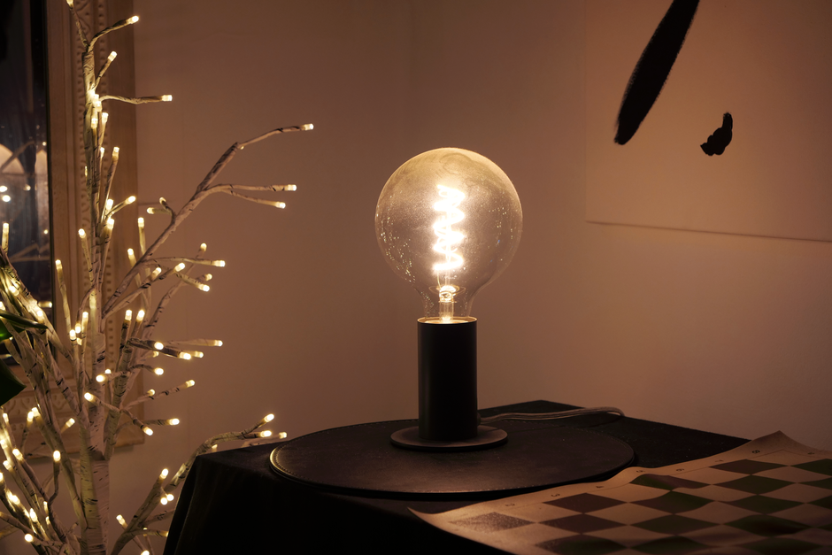 Warm lighting from LED bulb on table, creating a cozy indoor ambiance.