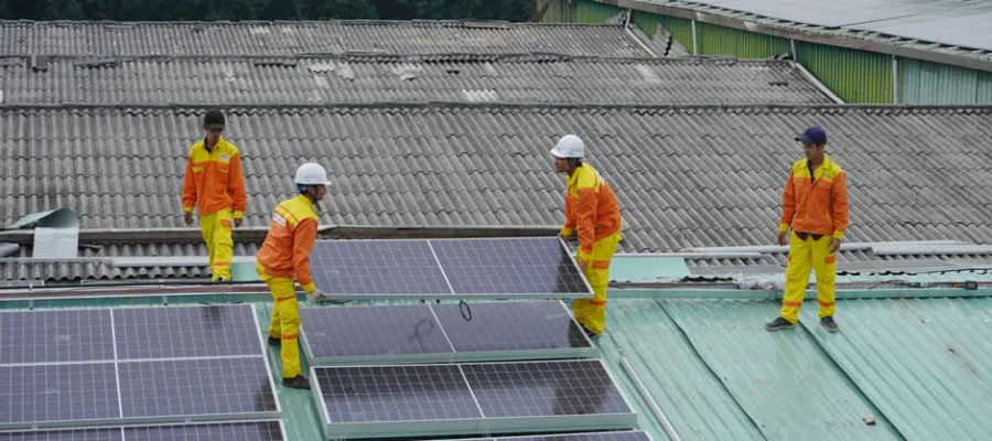 Workers installing solar panels on a roof for sustainable energy solutions.