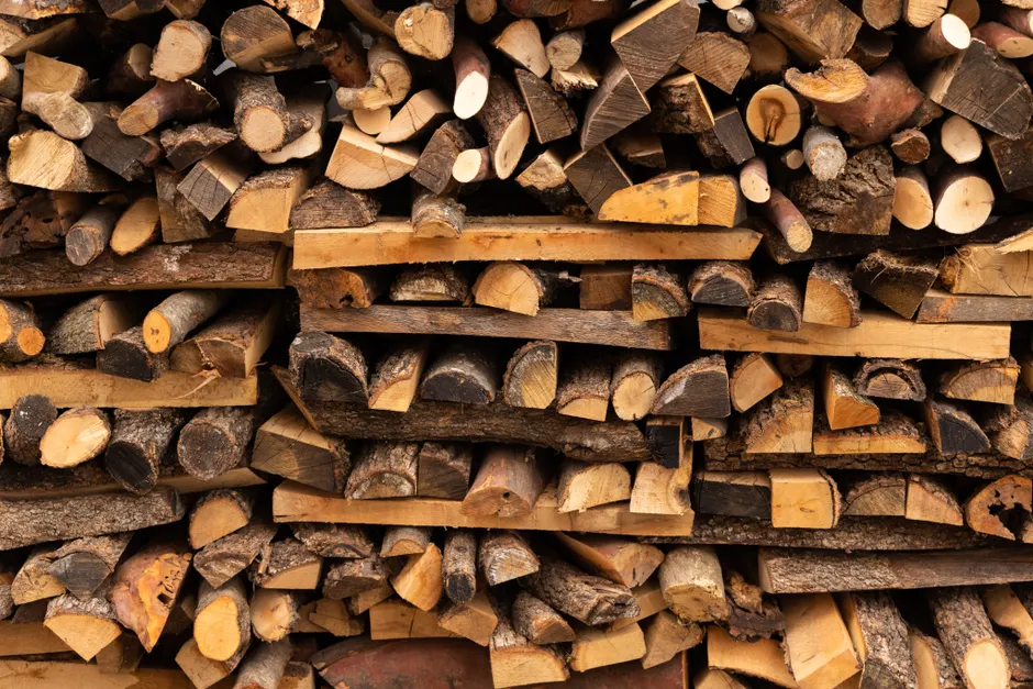 A close-up of neatly stacked firewood logs, perfect for outdoor heating or rustic decor.