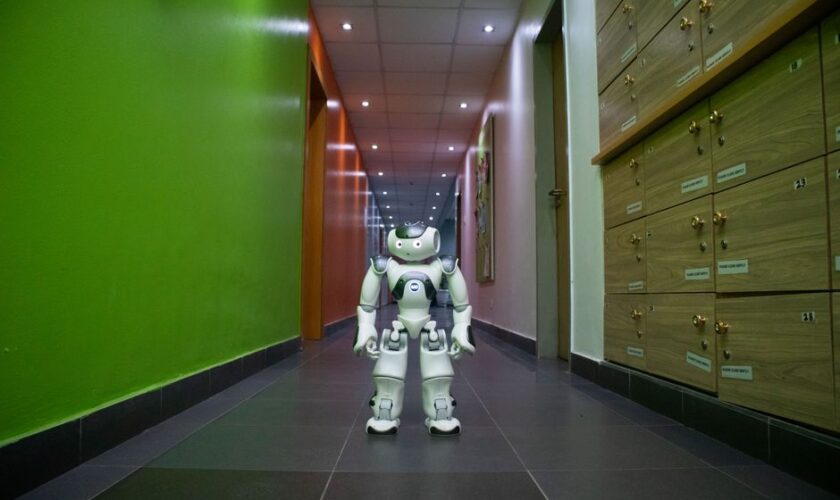 A humanoid robot stands in a vibrant, modern hallway in Lagos, Nigeria.