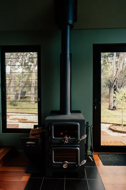 A modern wood-burning stove inside a home offering warmth with scenic outdoor views.