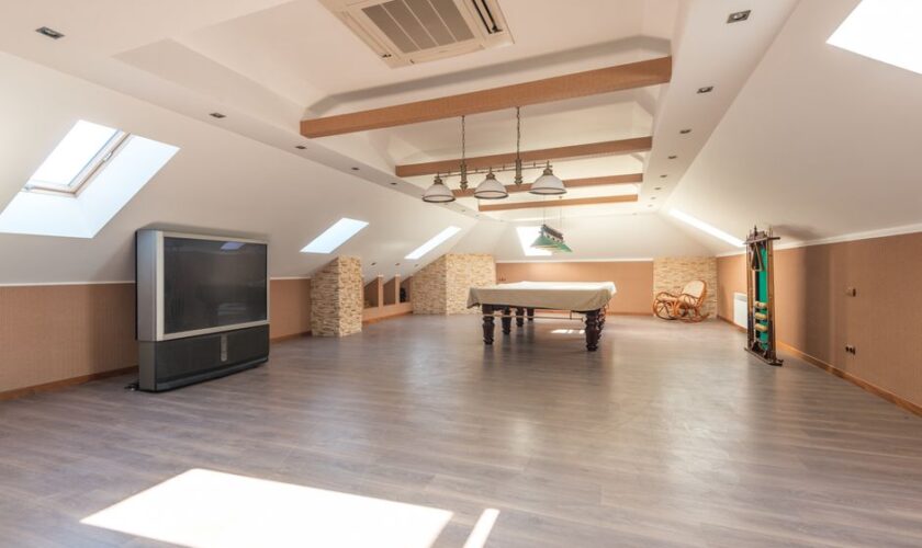 Bright attic space featuring a sleek pool table and skylights, perfect for leisure.