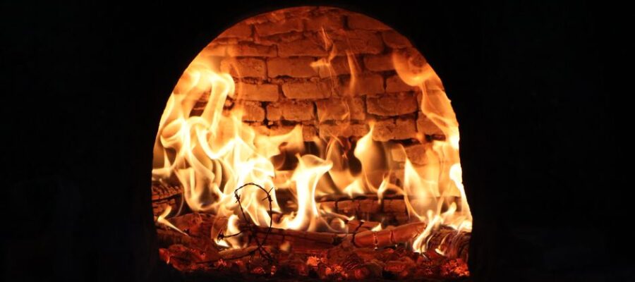 Captivating image of a roaring fire inside a traditional wood-fired oven, exuding warmth and rustic charm.