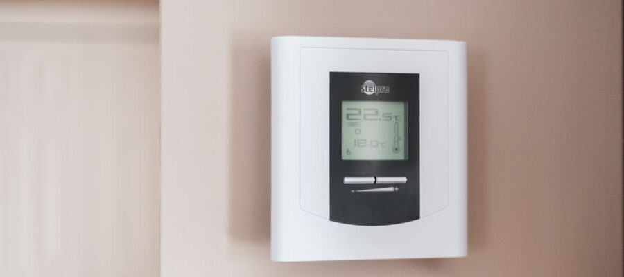 Close-up of a modern digital thermostat mounted on a wall, displaying temperature settings in Celsius.