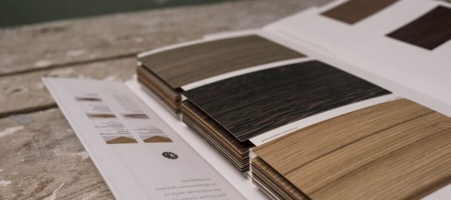Collection of wood veneer samples displayed on a rustic wooden table indoors.