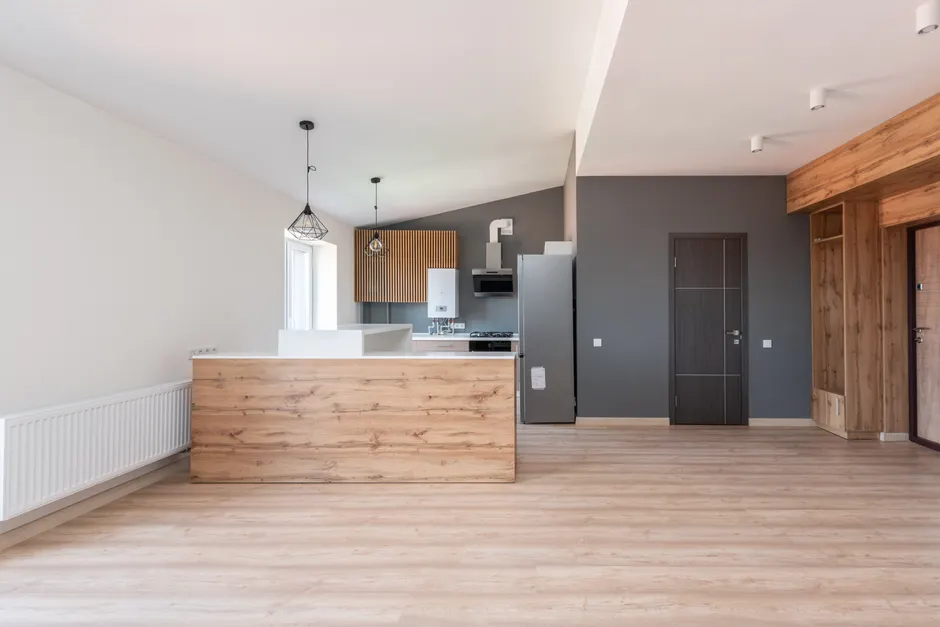Explore a stylish and minimalistic open-plan kitchen with wood accents and modern design.