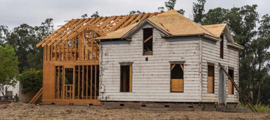 Image of an old house under renovation with new wooden frame structure.