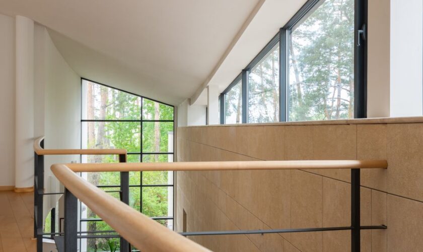 Interior of contemporary apartment with high geometrical ceilings and large windows in daytime