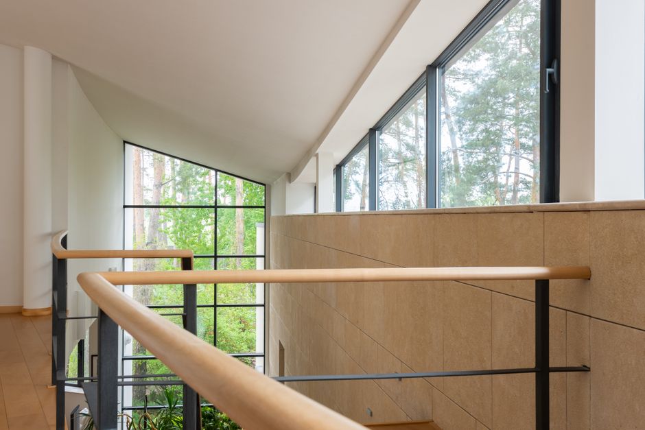 Interior of contemporary apartment with high geometrical ceilings and large windows in daytime