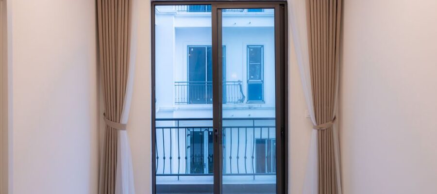 Interior view of a modern room featuring a large sliding glass door with elegant curtains.