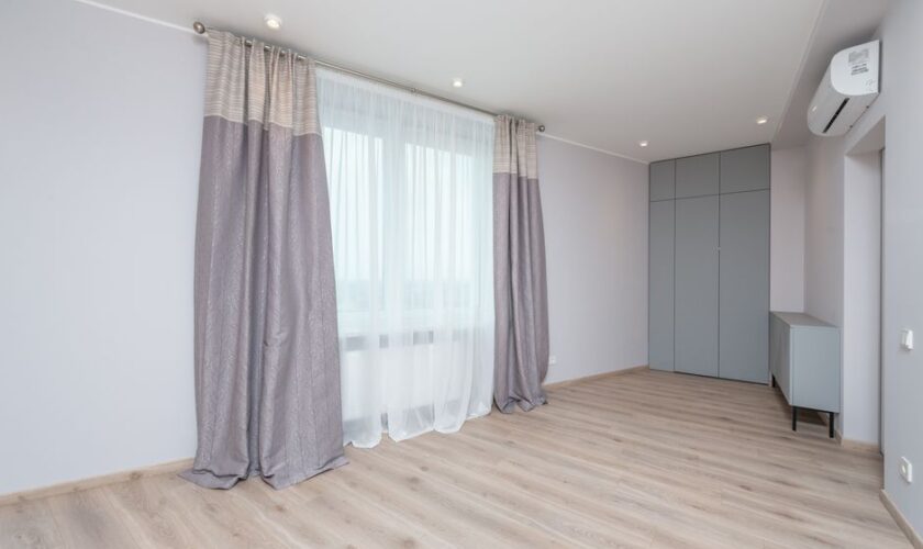 Modern room interior with cabinet and closet on floor under air conditioning and lamps in light house