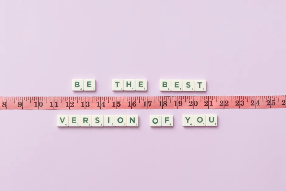 Motivational phrase 'Be the Best Version of You' with a measuring tape on purple background.