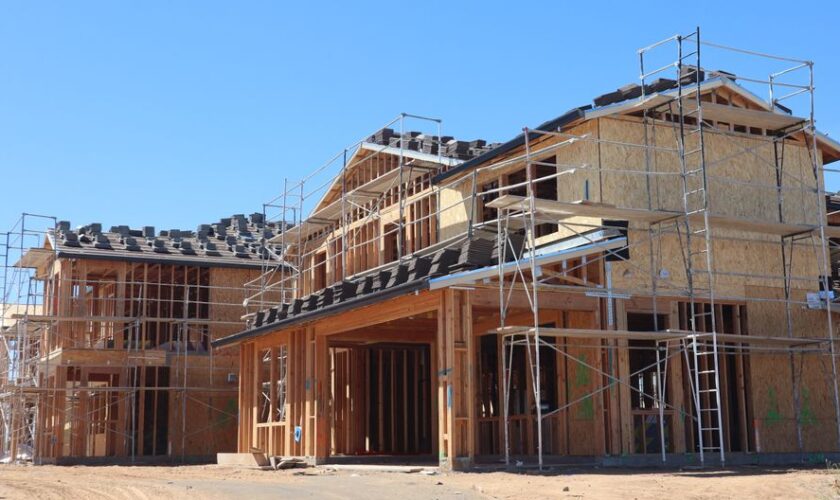 New residential homes under construction with scaffolding, showcasing modern architecture.
