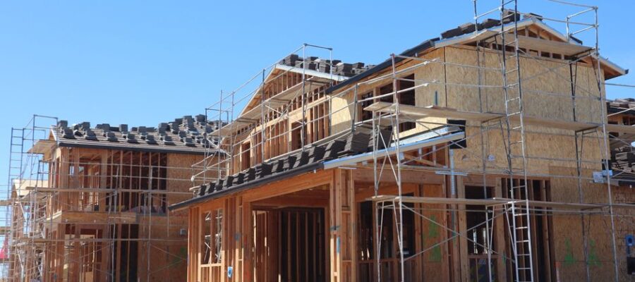 New residential homes under construction with scaffolding, showcasing modern architecture.