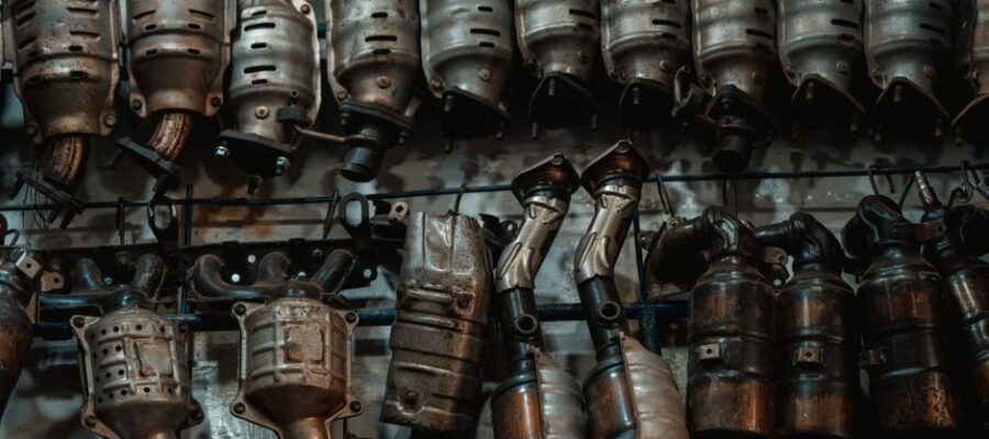 Rows of used catalytic converters in an automotive workshop setting.