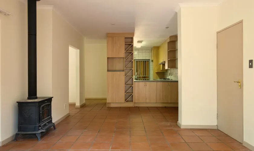 Spacious living area with a modern kitchen, warm tones, and a wood-burning stove.