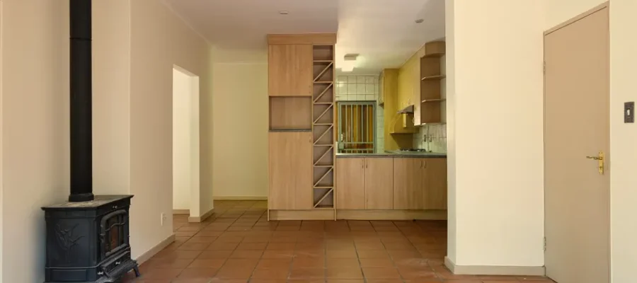 Spacious living area with a modern kitchen, warm tones, and a wood-burning stove.