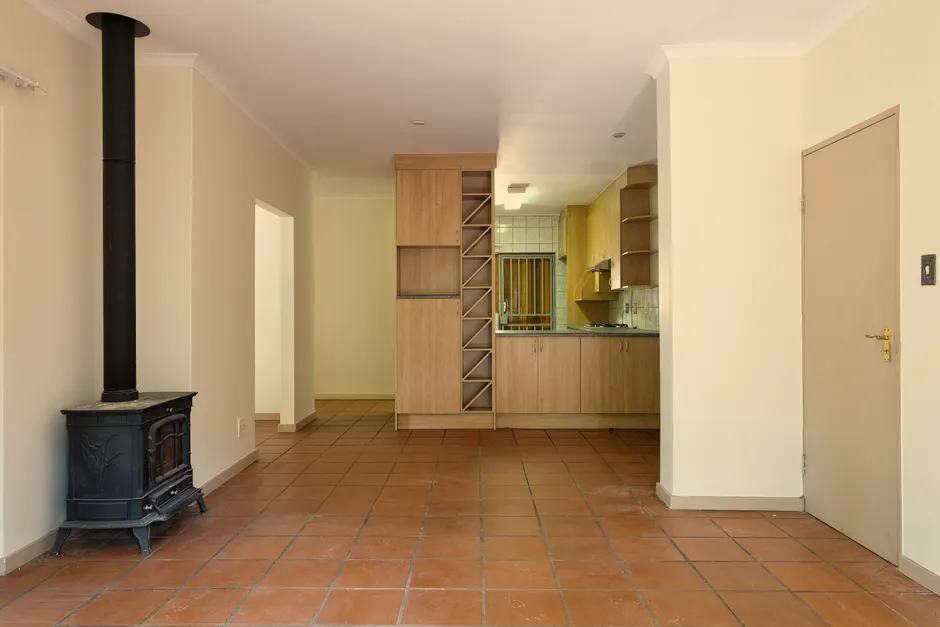 Spacious living area with a modern kitchen, warm tones, and a wood-burning stove.