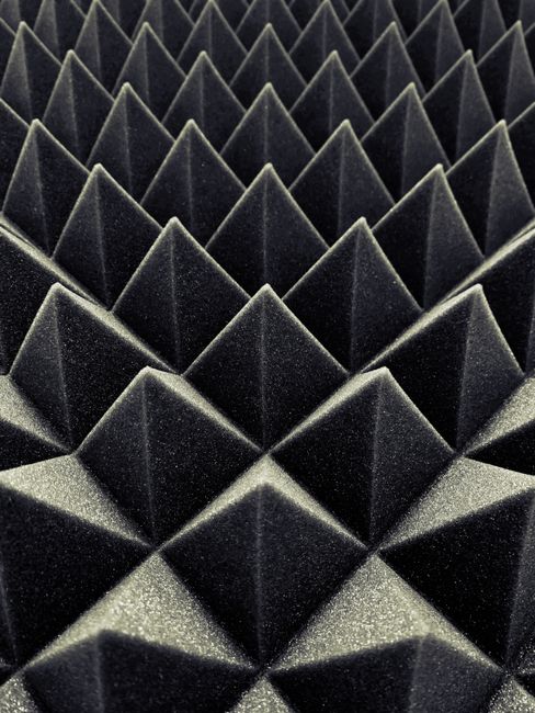 Textured black acoustic foam panels create a striking geometric pattern.