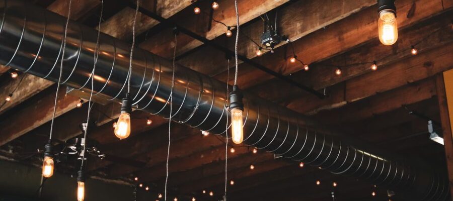Wooden ceiling featuring industrial hanging lights and exposed ductwork for a modern rustic look.