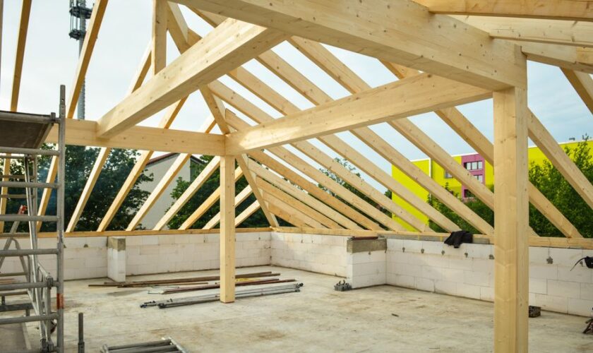 Wooden roof structure in progress with open sky view, ideal for construction themes.